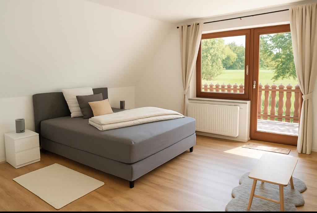 a bedroom with a bed and a large window at Ferienwohnung Fehnzeit in Rhauderfehn