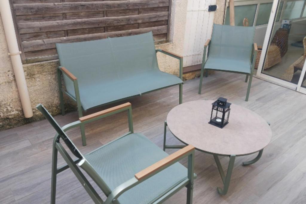 three chairs and a table with a lamp on a patio at Peaceful house in the heart of Boutonnet in Montpellier