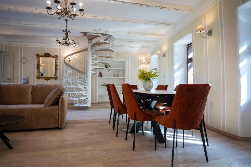 a dining room with a table and chairs and a couch at Apartmaji Hiša kranjske čebele in Višnja Gora