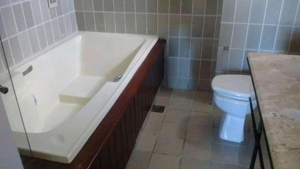 a bathroom with a bath tub and a toilet at Cobertura no Centro de Guarapari in Guarapari