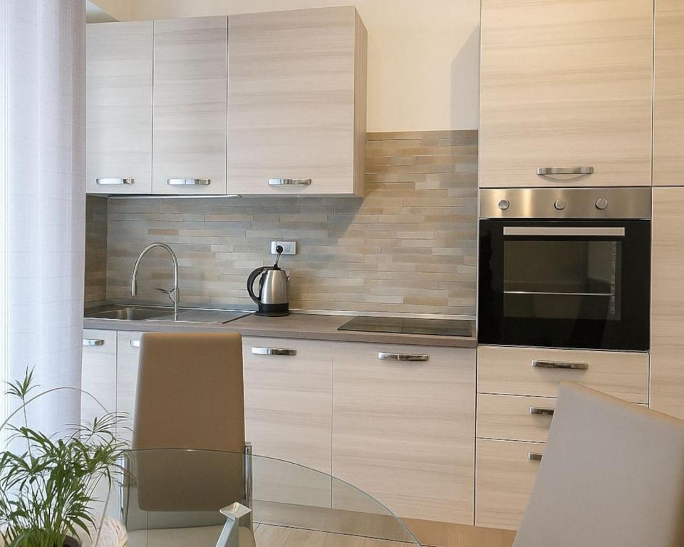 a kitchen with wooden cabinets and a sink and a microwave at Casa vacanze Torino con vasca idromassaggio in Turin
