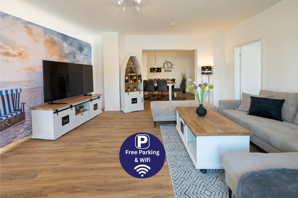 Una sala de estar con un televisor de pantalla plana grande. en Captains Nest - Modernes, zentrales Apartment mit Garage von STAY YOUR WAY, en Bremerhaven