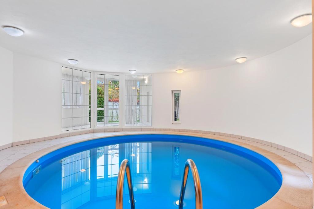 een groot zwembad met blauw water in een huis bij Black Dragon Haven Villa with Pool Sauna Jacuzzi BBQ & Parking for 8 Cars in Praag