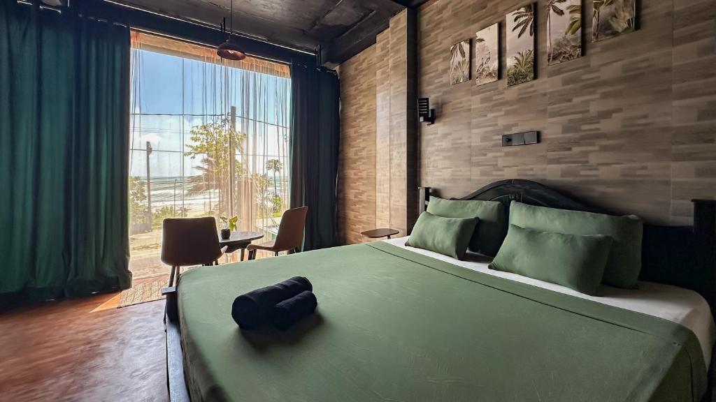 a bedroom with a large bed and a large window at Arana Weligama in Weligama