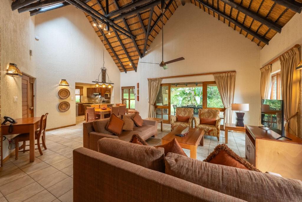 a living room with couches and a dining room at Kruger Park Lodge Unit No 237 in Hazyview
