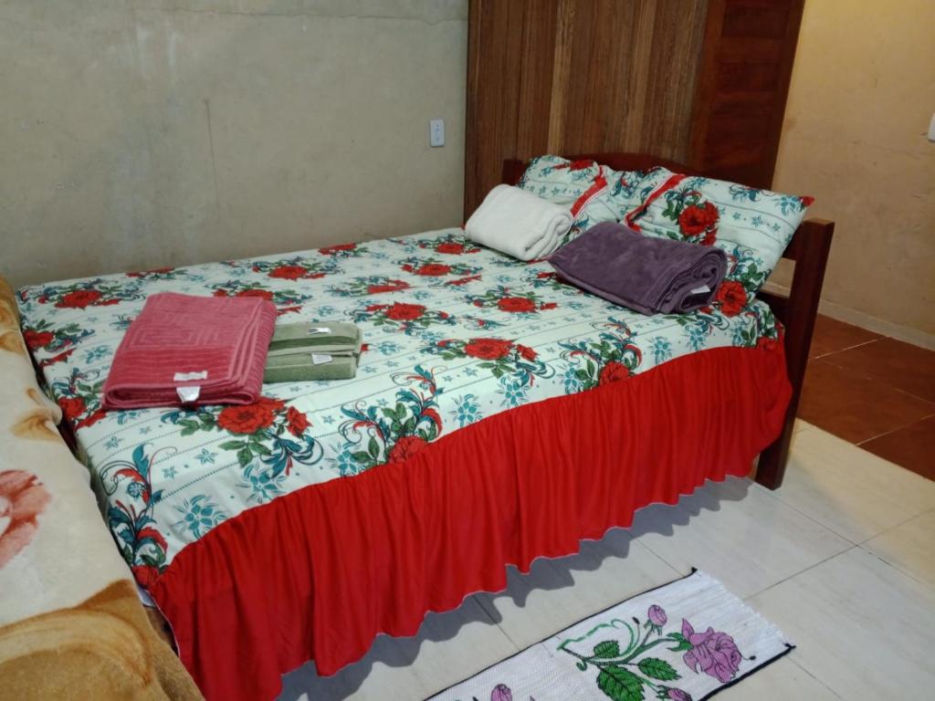 1 dormitorio con 1 cama con colcha de flores en Quarto completo, en Ananindeua