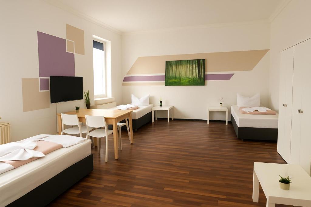 a room with two beds and a table and chairs at SUNNYHOME Monteurwohnungen und Apartments in Schwandorf in Schwandorf in Bayern