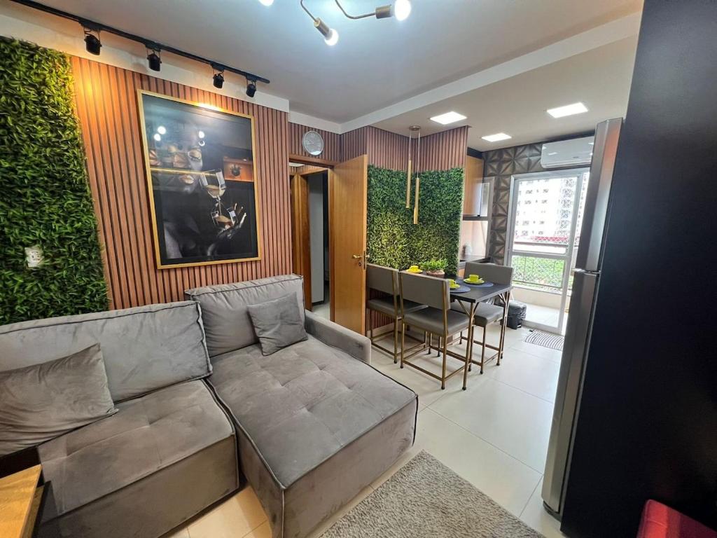 un soggiorno con un divano e un tavolo di Ap Setor universitário a Goiânia