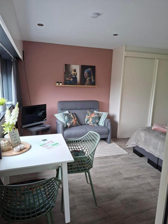 a living room with a couch and a bed at Sfeervolle 2 persoons studio in Bakkeveen in Bakkeveen