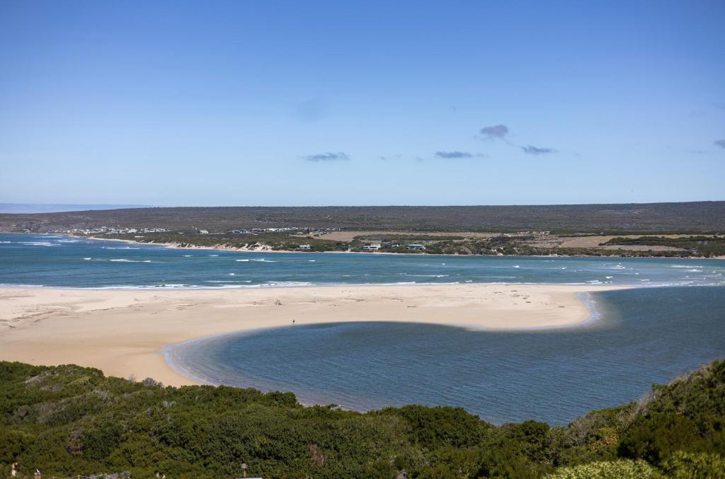 a beach with a group of people in the water at Amia in Witsand