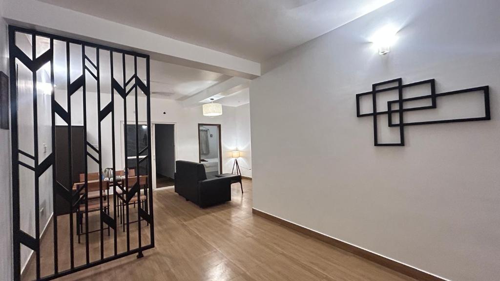 a living room with a table and a chair and a wall at The Base Inn in Puducherry