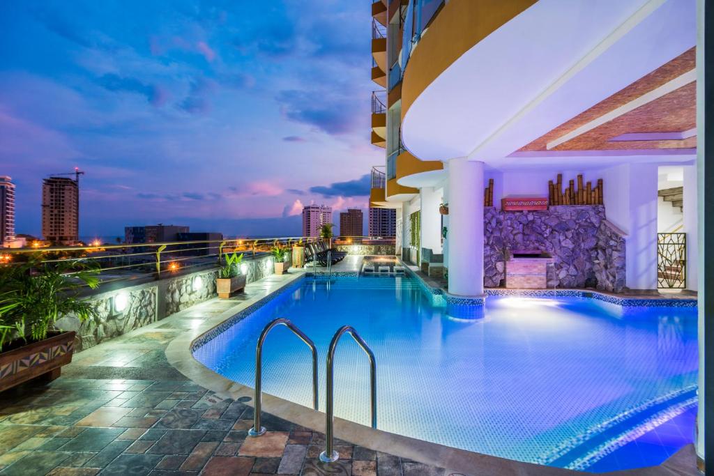 a pool on the roof of a building at night at Terrazas Tayrona Travelers Apartamentos y Suites in Santa Marta