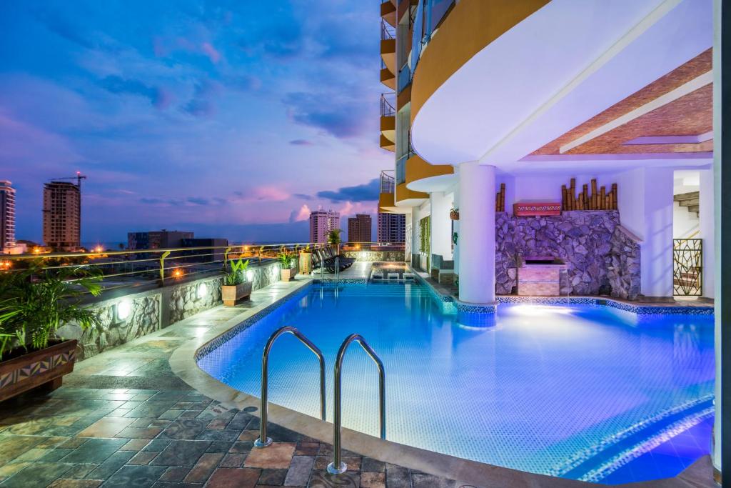 una piscina en la azotea de un edificio por la noche en Terrazas Tayrona Travelers Apartamentos y Suites, en Santa Marta