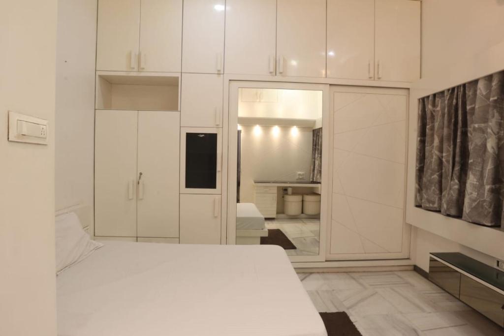 a bedroom with white cabinets and a white bed at House of Raghuvansh in Jodhpur