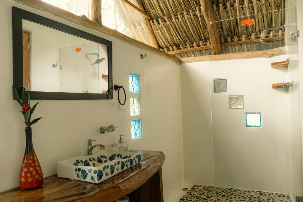 a bathroom with a sink and a mirror on the wall at Cabañas Tucan Eco Hotel in Capurganá