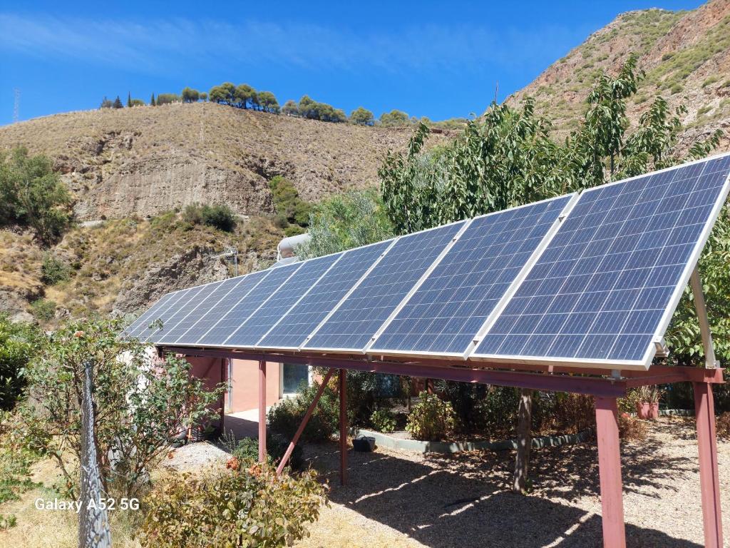 a house with solar panels on the side of a mountain at Aguas Calmas in Nigüelas