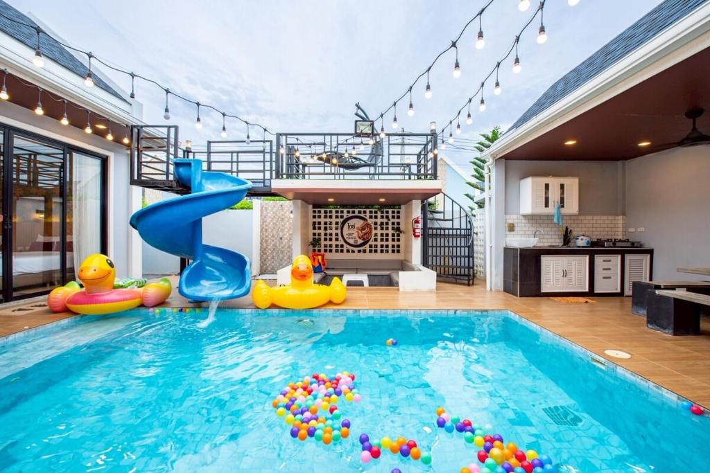 a swimming pool in a house with a slide at Ice Dragon Pool Villa ไอซ์ดราก้อน พูลวิลล่า in Ban Map Fakthong