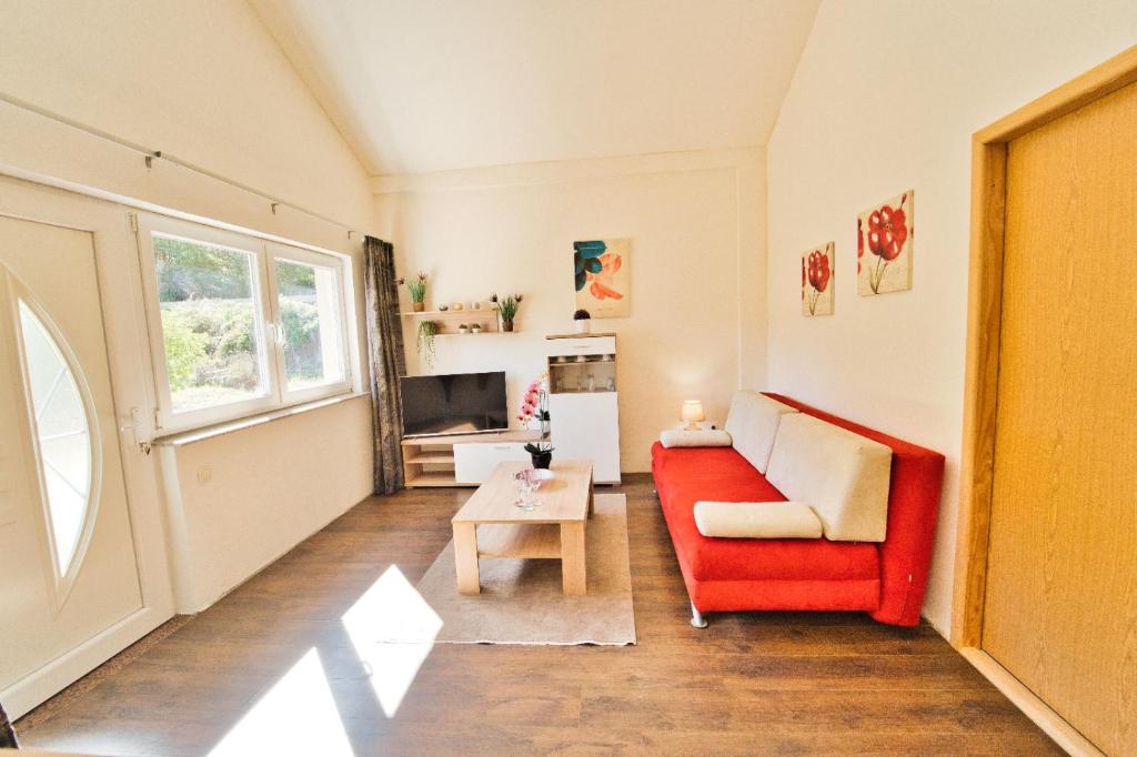 a living room with a red couch and a table at Apartment Chantal in Mostar
