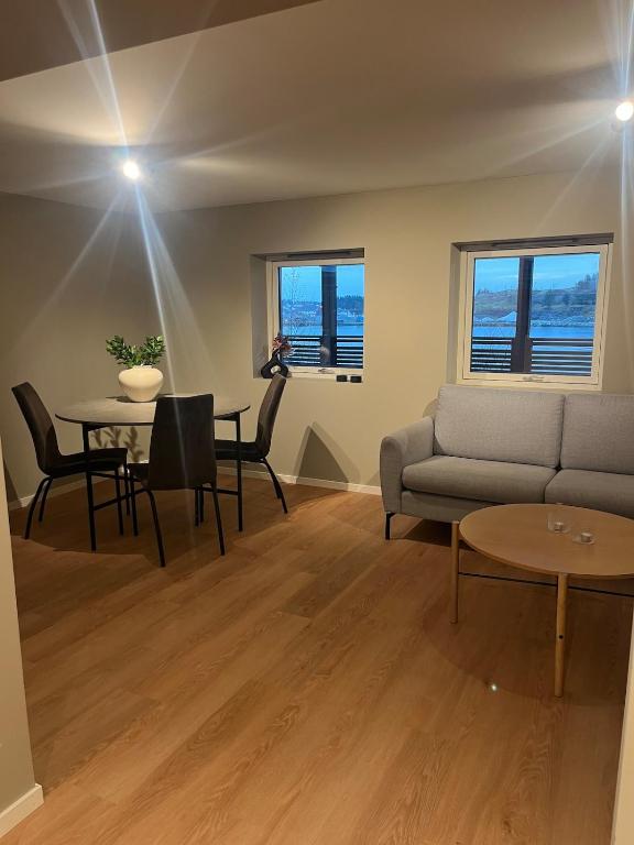 a living room with a couch and a table at Apartment right by Karmsund in Karmøy