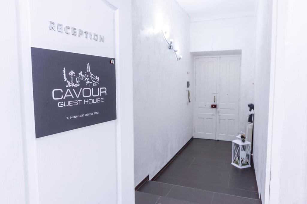 un pasillo con una habitación blanca con un cartel en la pared en Cavour Guest House, en Ventimiglia