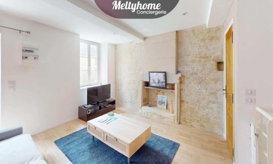 a living room with a couch and a coffee table at Charme, plage & tout à pied in Luc-sur-Mer