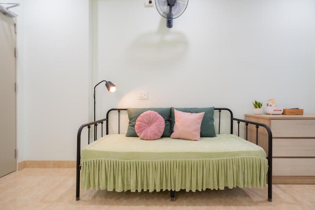 a bedroom with a bed with pink and green pillows at AnhHouse85 Da Nang - 750 meters from the beach - Free airport pick up and free modern coffee machine provided in Da Nang