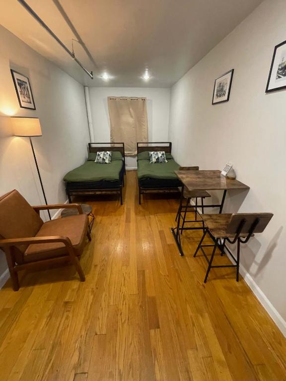 una stanza con due letti, un tavolo e delle sedie di Union Square Studio with Kitchen -Shared Bathroom a New York
