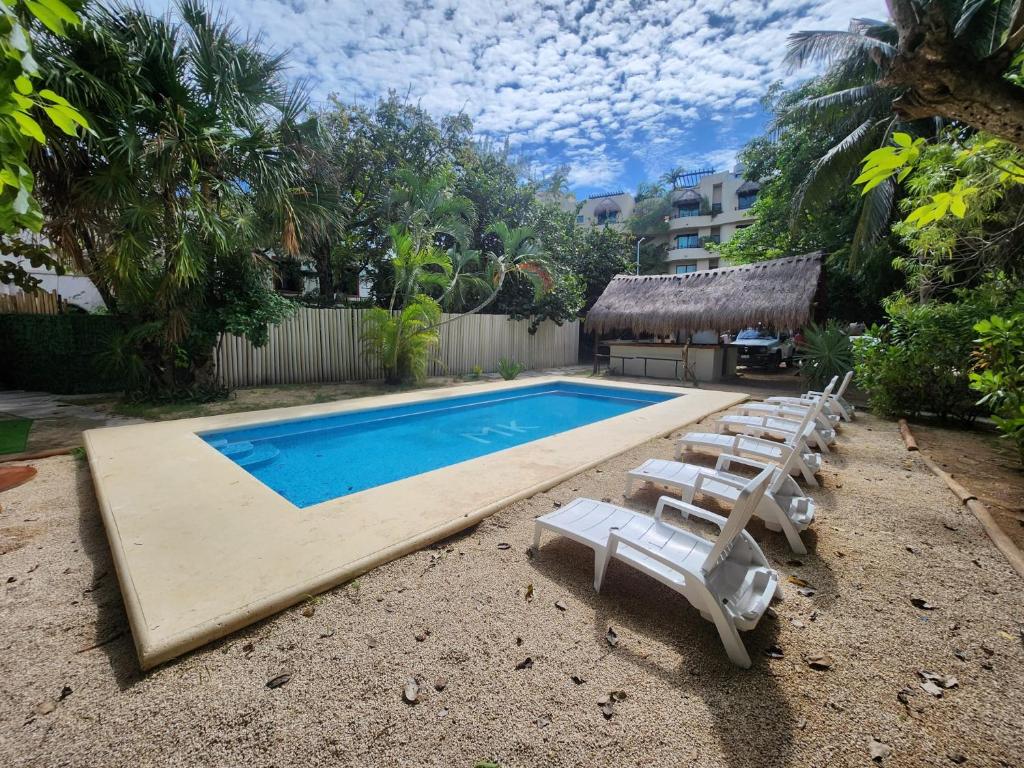 a swimming pool with chaise lounge chairs and a swimming pool at MK BEACH Playa Del Carmen in Playa del Carmen