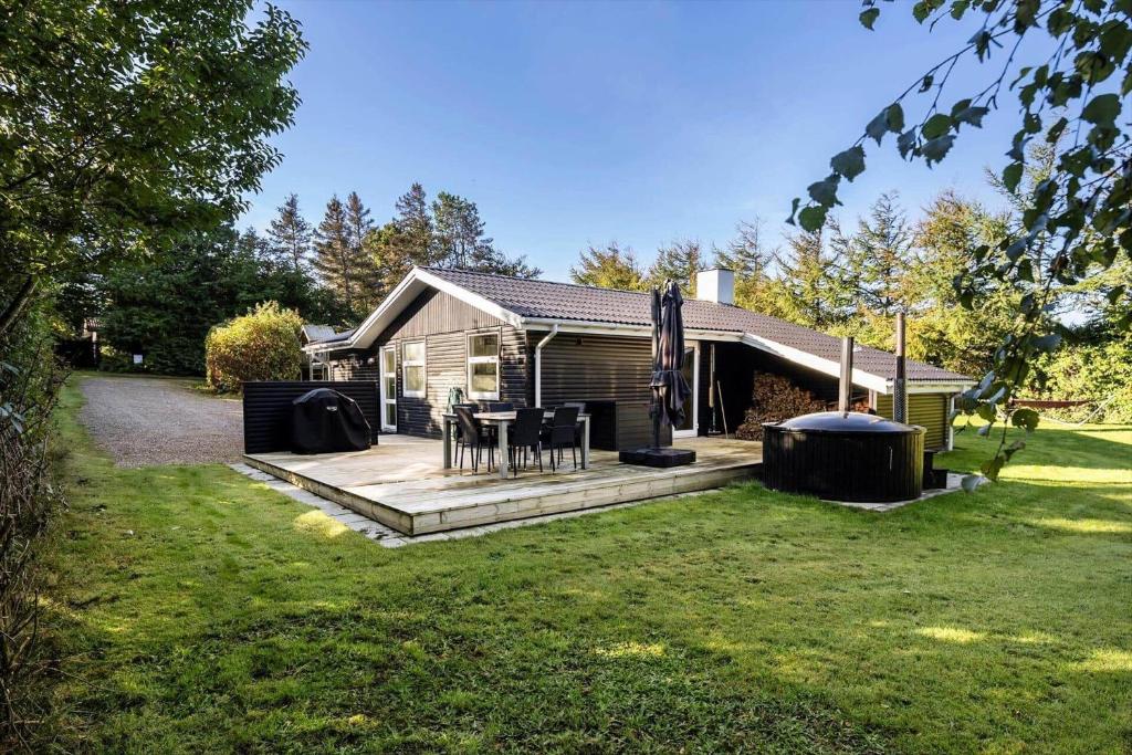 a house with a deck with a table and chairs at LF16121-Farso-Bjarkesvej-11 in Farsø