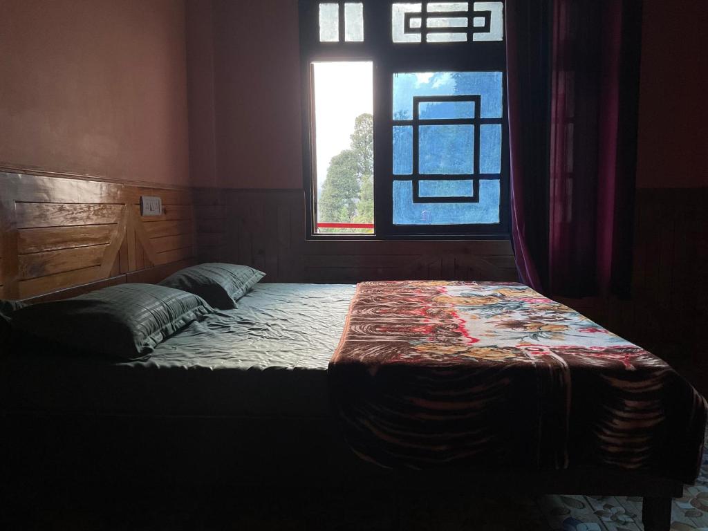a bed in a room with a window at The Balcony at Greensmile in Shilha Village