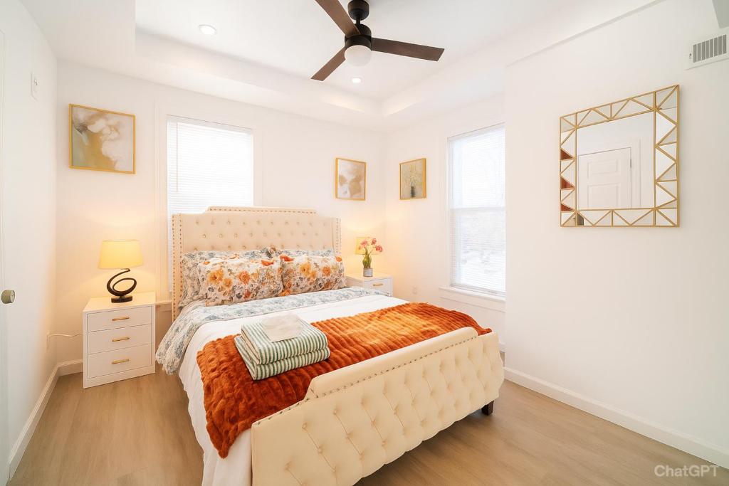 een witte slaapkamer met een bed en een plafondventilator bij Spacious 5 Bedroom Washington DC Home Near Metro with Free Parking in Washington