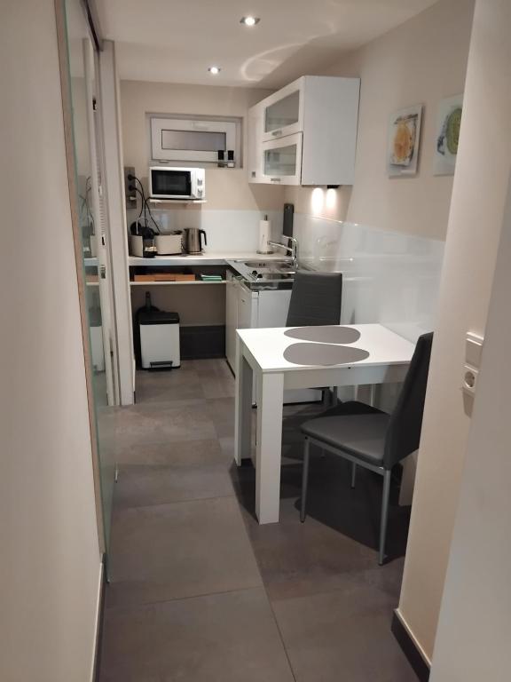 una pequeña cocina con mesa blanca y sillas en Tango apartment, en Breitenworbis