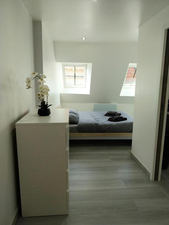 a bedroom with a bed and a table with flowers on it at Duplex chic et pratique in Nogent-sur-Seine