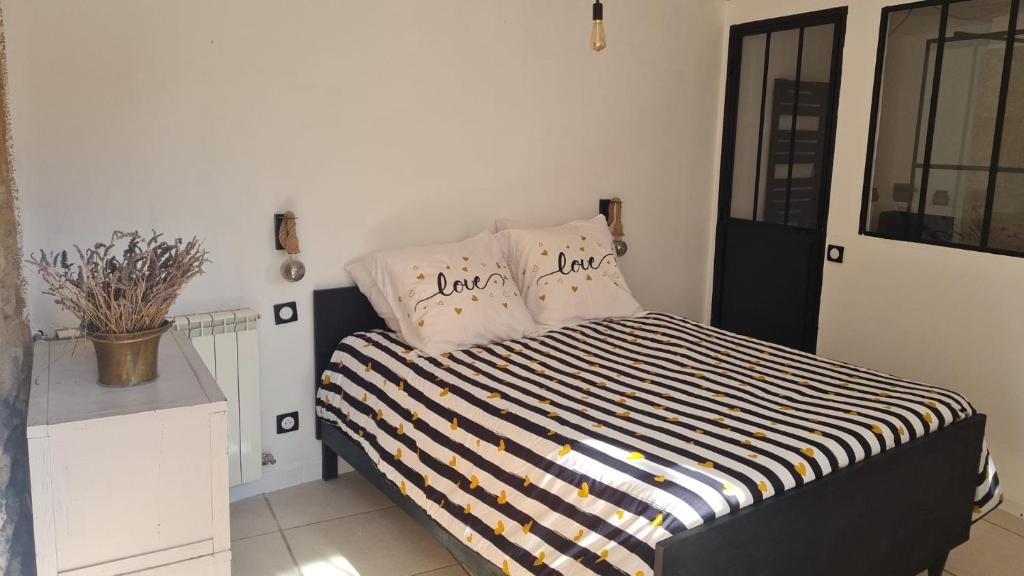 Una cama con dos almohadas encima en una habitación. en La Fontaine, en Beaumont-du-Ventoux