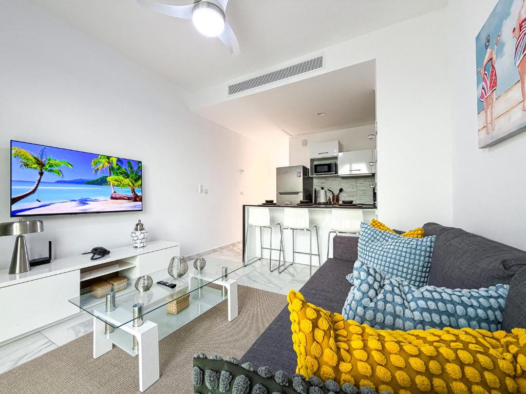 Una sala de estar con un sofá y un televisor. en Cana Rock Penthouse Golf Views & Infinity Pool, en Punta Cana