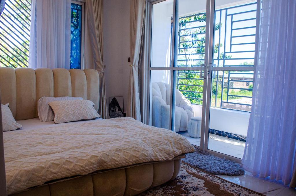 a bedroom with a bed and a large window at Daisy Apptment in Malindi