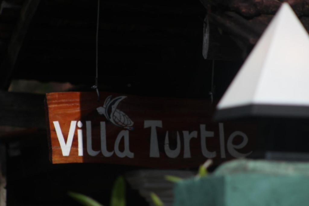 a sign that readsilla turtle hanging from a building at Villa Turtle in Galle