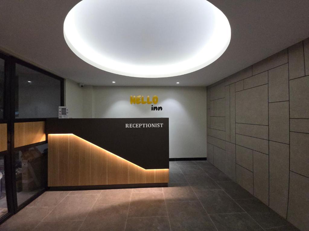 a lobby with a sign on the wall and a light at Hello Inn permata hijau in Stasiun Tawang