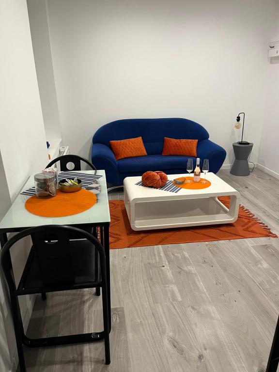 een woonkamer met een blauwe bank en een tafel bij Violette 2 in La Souterraine