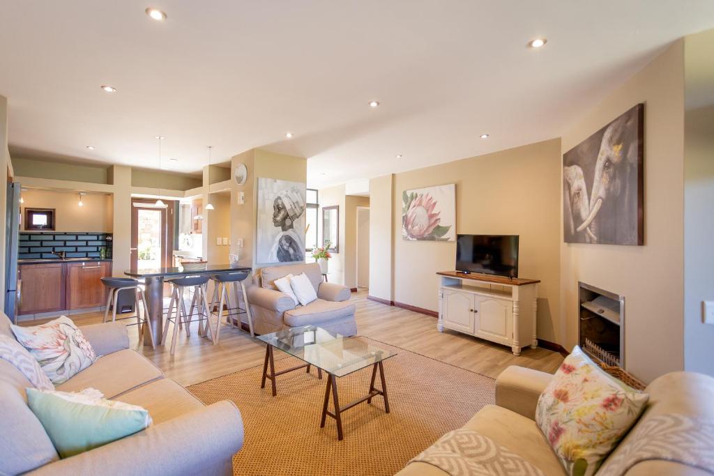 ein Wohnzimmer mit zwei Sofas und einem Tisch in der Unterkunft Terrace Tranquility at Oubaai Golf Estate in Herolds Bay