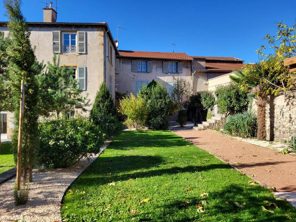 ein Haus mit einem Rasen davor in der Unterkunft Grand Gîte au cœur du village avec jardin in Regny