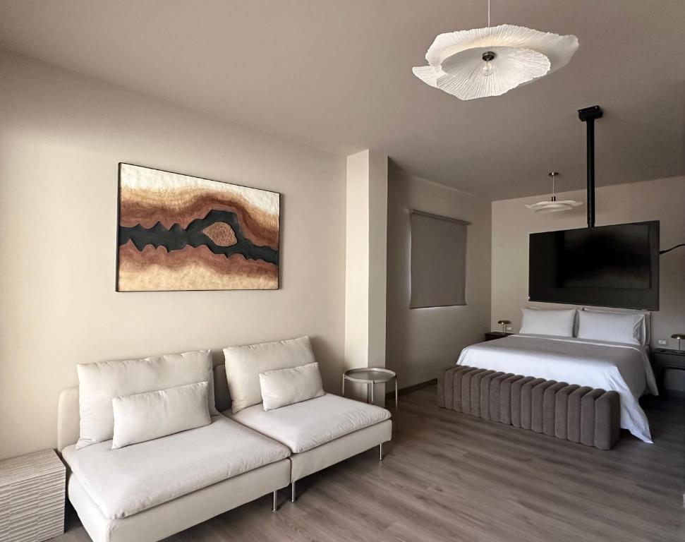 1 dormitorio con sofá, cama y TV en Coffee apartamento, Las Galletas, en Arona