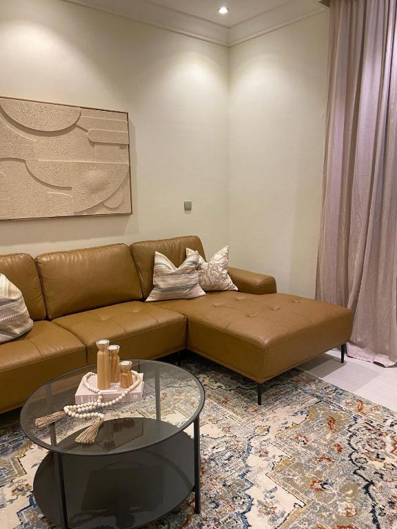 a living room with a couch and a glass table at شقة بغرفتي نوم وغرفة معيشة in Jeddah