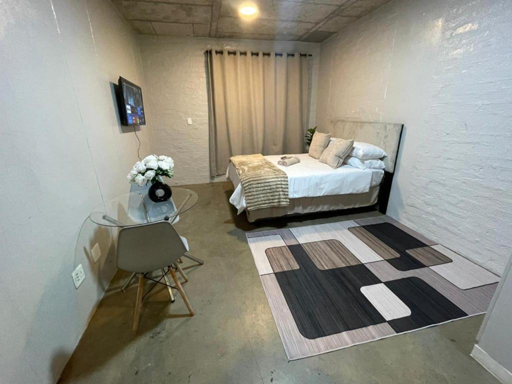 a room with a bed and a table in a room at Serenity sleep in Johannesburg