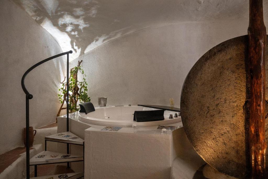 a bathroom with a bath tub and a large mirror at Grotta azzurra - Suite e spa in Monticelli