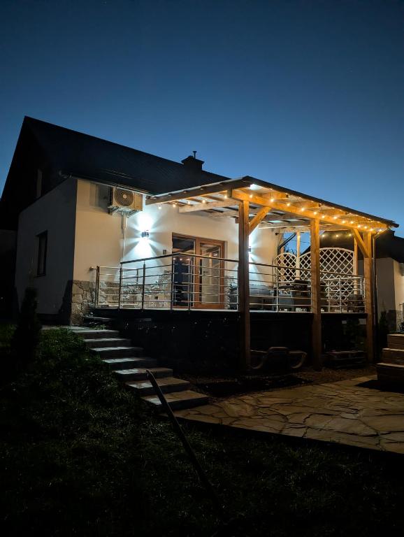 a house with lights on the front of it at night at Domki Pod Chełmem in Brunary Niżne