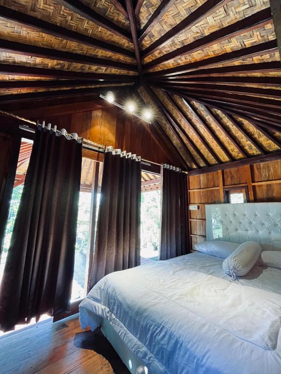 a bedroom with a large bed in a wooden ceiling at Arina's Cabin in Aik Berik