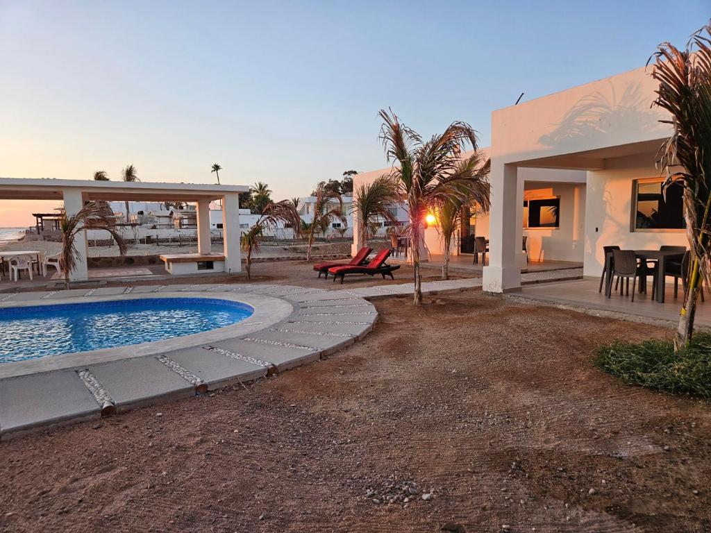 a villa with a swimming pool and a house at Camahuiroa Bungalows in Camahuiroa