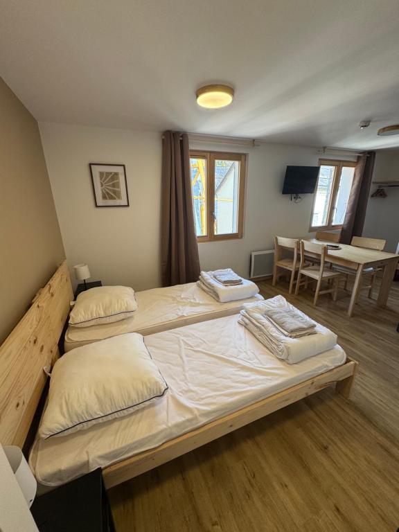 een slaapkamer met 2 bedden en een tafel en een eetkamer bij Résidence le Prorel - Serre chevalier in Saint-Chaffrey