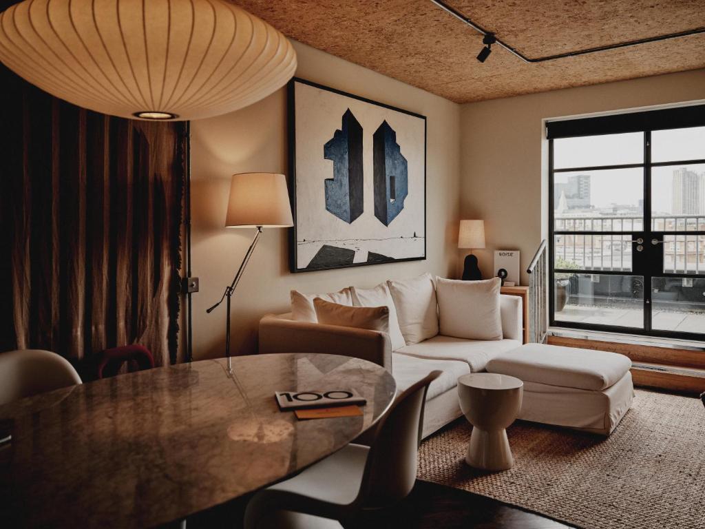 a living room with a couch and a table at One Hundred Shoreditch in London
